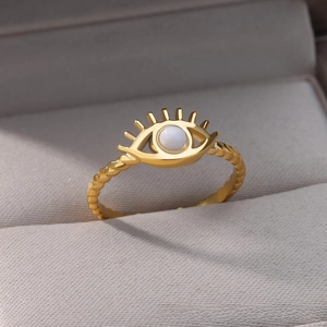 Macro detail of gold-plated evil eye ring with twisted band and white stone inlay