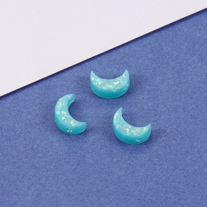 Macro shot of 7x10.5mm blue resin moon beads with shimmering opal effect for DIY jewelry