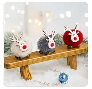 Three festive felt reindeer figurines with wooden details in a cozy Christmas scene