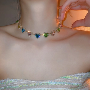 Dettaglio della collana con cristalli colorati a cuore e strass su una modella