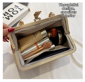 Internal view of shell bag showing spacious storage for phone and cosmetics with pearl strap