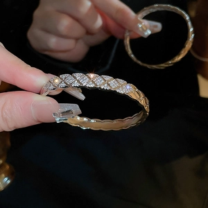 Macro detail of silver lattice bracelet featuring quilted patterns and pavé-set zircons