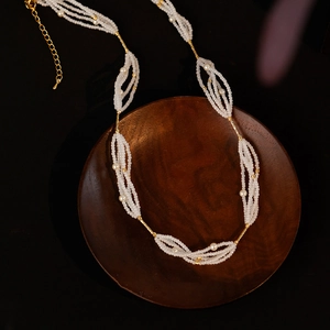 Elegant multi-strand pearl necklace with gold bead accents and adjustable extension chain