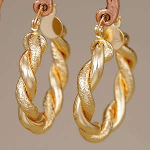 Elegante goldene gedrehte Creolen mit strukturierter Oberfläche und poliertem Design