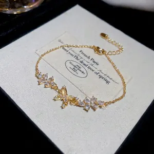 18k gold plated bracelet featuring butterfly and flower charms with zircon and cat's eye stone