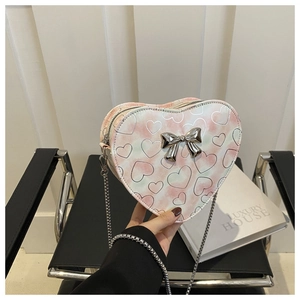 Pink gradient heart-shaped bag with silver bow detail and metal chain strap shown by model