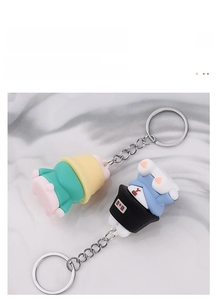 Detail of colorful PVC sleeping bear keychains with metal rings on marble background