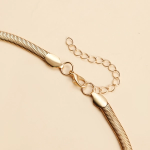 Detail of gold snake chain necklace featuring a lobster clasp and adjustable extender