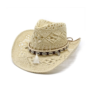 Detail of hollow-out woven straw cowboy hat with shell beads and tassel band