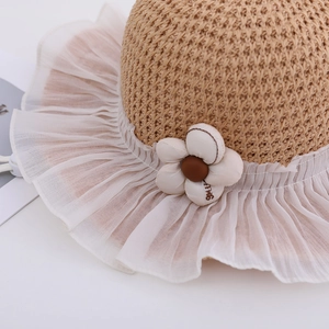 Close-up of children's straw sun hat with delicate chiffon brim and a 'Smile' flower detail