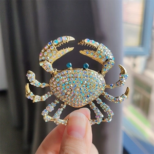 Close-up of sparkling crab brooch featuring colorful AB crystals and blue rhinestone eyes