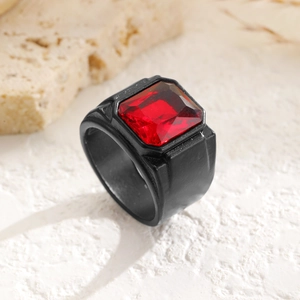 Makroaufnahme eines Herrenrings mit dunkelrotem Edelstein und schwarzem Matt-Finish