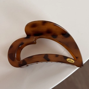 Detail of tortoiseshell hair claw with a gold oval plaque engraved with Love script