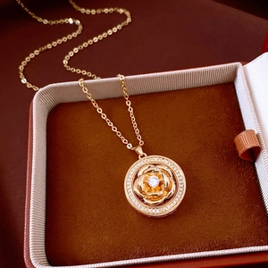 Macro shot of gold vintage rose pendant necklace with sparkling cubic zirconia in a jewelry box