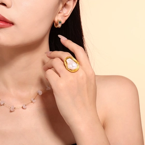 Fashionable gold irregular titanium steel ring featuring a white faux pearl on model