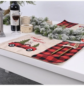 Detail of Christmas linen placemat with red truck embroidery and cutlery pocket