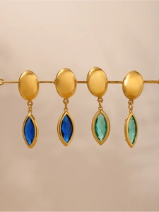 Détail de boucles d'oreilles marquise en cristal vert émeraude et bleu foncé sur tiges d'or