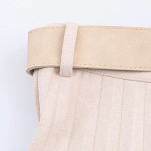 Gros plan sur une jupe en daim beige avec coutures soignées et ceinture assortie à la taille