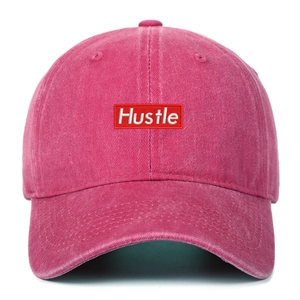 Detailed front view of washed peach red baseball cap with embroidered Hustle patch