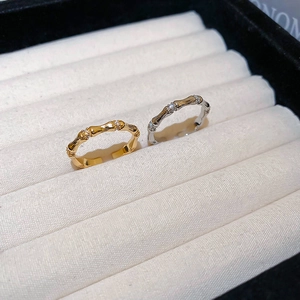 Detailed view of gold and silver bamboo rings with zircon insets on white velvet