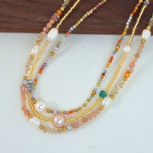 Macro detail of freshwater pearls and colorful crystal beads on a handmade necklace