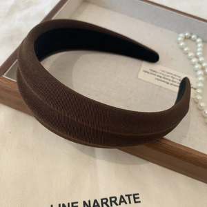 Detail of dark brown fabric headband with thick texture and black non-slip inner lining