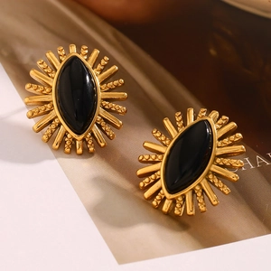 Macro detail of vintage 18K gold plated stainless steel stud earrings with black agate eyes