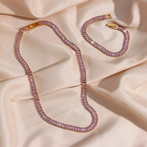 Detailed macro of gold-plated necklace and bracelet set with lilac rectangular zircons