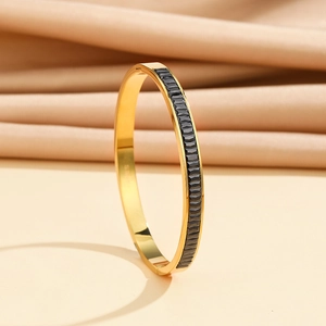 Detail view of gold stainless steel oval bangle with black square gemstones and hinge