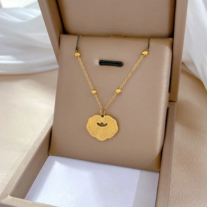 Detailed close-up of golden titanium steel ruyi lock pendant with fu character in gift box