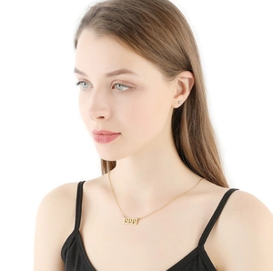 Gros plan d'un collier en acier inoxydable doré avec l'année 1999 sur un mannequin femme