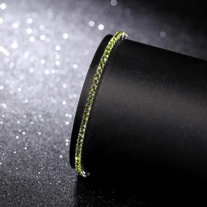 Close-up of flexible 2.0mm silver bracelet featuring green crystal rhinestones on a stand