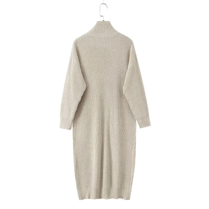 Close-up of beige chunky knit texture and button details on a long cardigan sweater