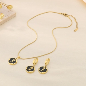Detailed shot of golden necklace and earrings set featuring black enamel rose pendants