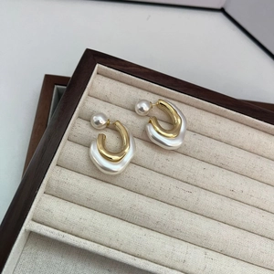 French style gold U-shaped metal earrings with white pearls in a jewelry box