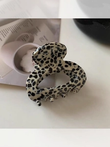 Close-up of a minimalist acrylic shark clip with black and white Dalmatian pattern spots