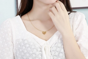 Close-up of golden heart pendant necklace on female model neck for Mother's Day