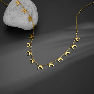 Minimalist gold stainless steel necklace with multiple crescent moon pendants on a stone