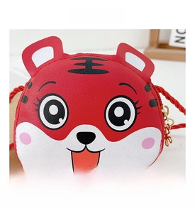 Detailaufnahme einer roten Cartoon-Tigertasche mit Litschi-Textur und goldenem Reißverschluss
