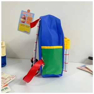 Side view of multi-color canvas preschool backpack with side grid pocket and red straps