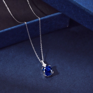 Macro view of a deep blue square-cut gemstone pendant on a silver necklace