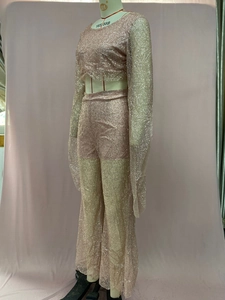 Detail of rose gold sequined two-piece set featuring long sleeve crop top and wide leg pants