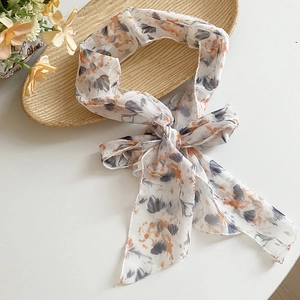 Macro detail of an elegant pastoral floral print mesh scarf necklace tied in a bow
