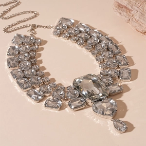 Detailed view of silver heart and geometric crystal pendant necklace with rhinestones