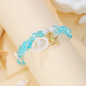 Detail of beach bracelet featuring blue gravel, faux pearls, starfish and shell charms