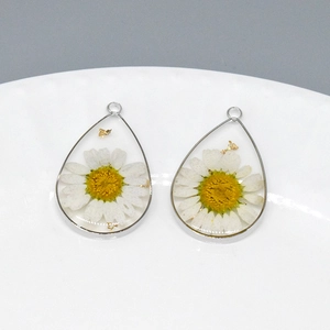 Detailed teardrop resin pendant featuring real white daisy and gold foil accents
