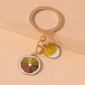 Detail of vibrant enamel orange and citrus slice pendants on a metal keychain