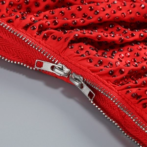 Detail of red evening dress showing dense rhinestones and silver metal zipper closure