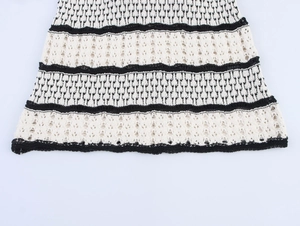 Detailed macro view of the black and white knitted dress hem showing crochet patterns