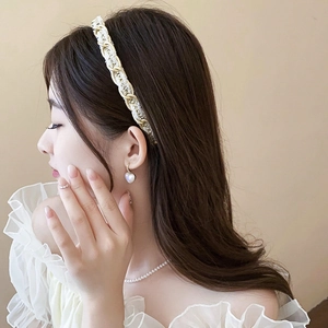 Détail d'un serre-tête tissé de style français avec perles et boucles d'oreilles cœur